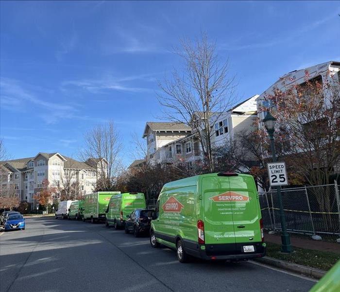 Green SERVPRO trucks in front of condo buildings