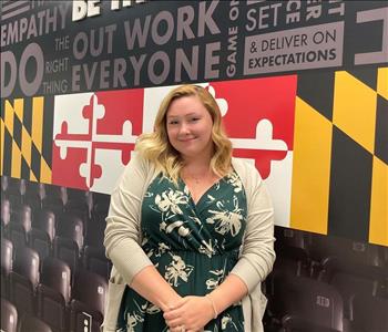 blonde female in front of mural wall with Maryland flag colors